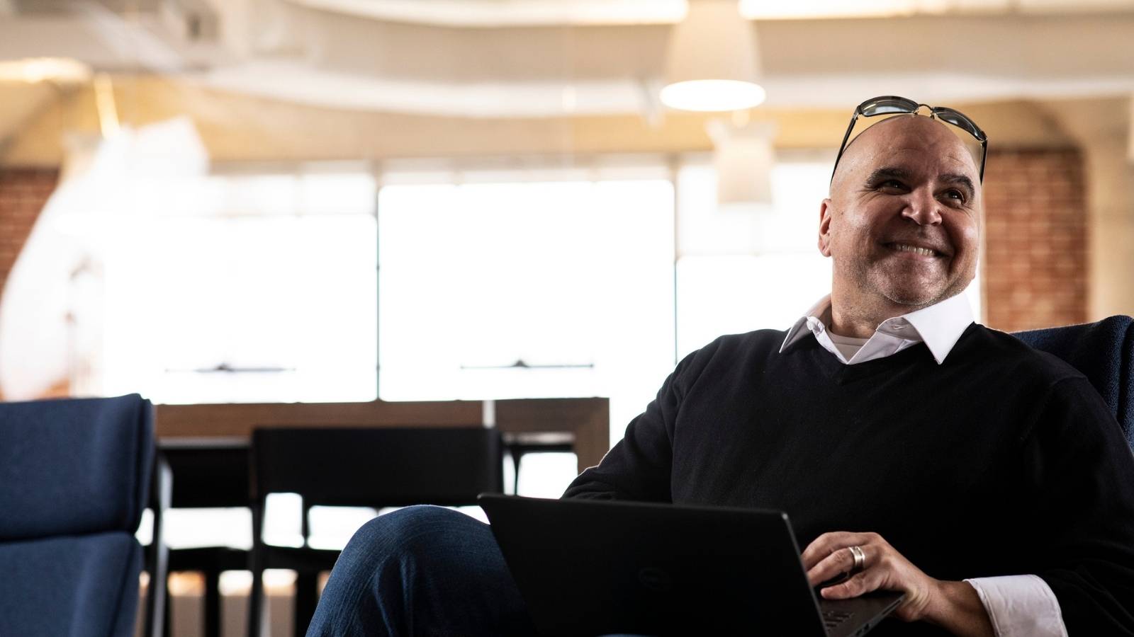 Cox employee smiling with his laptop