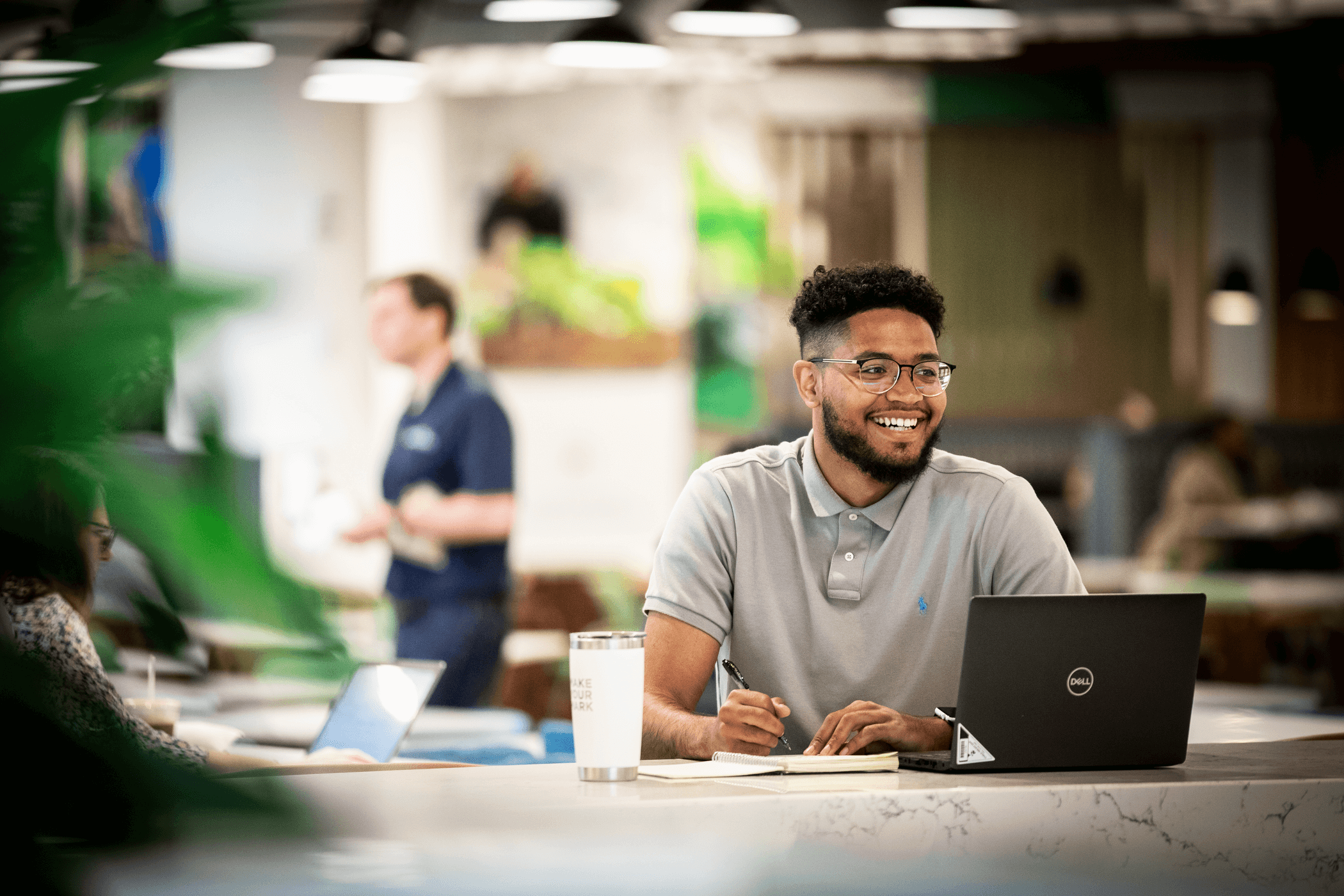 Cox employee working in the cafe with laptop and notepad