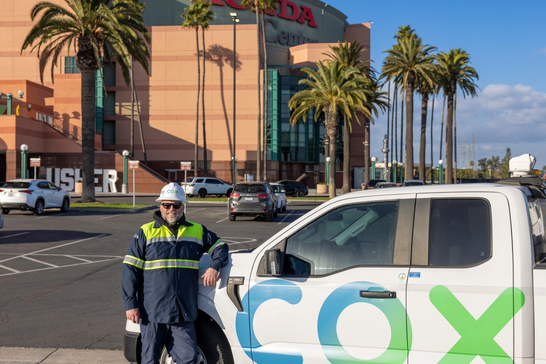 Cox automotive employee leaning on a car