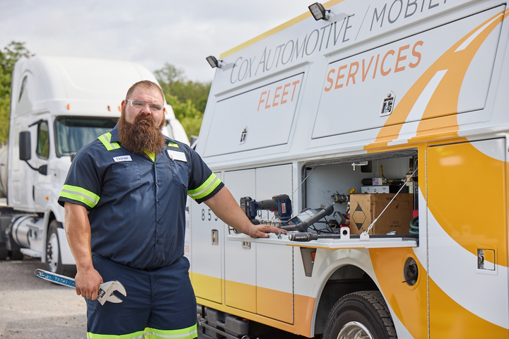 a Cox employee standing next to a van