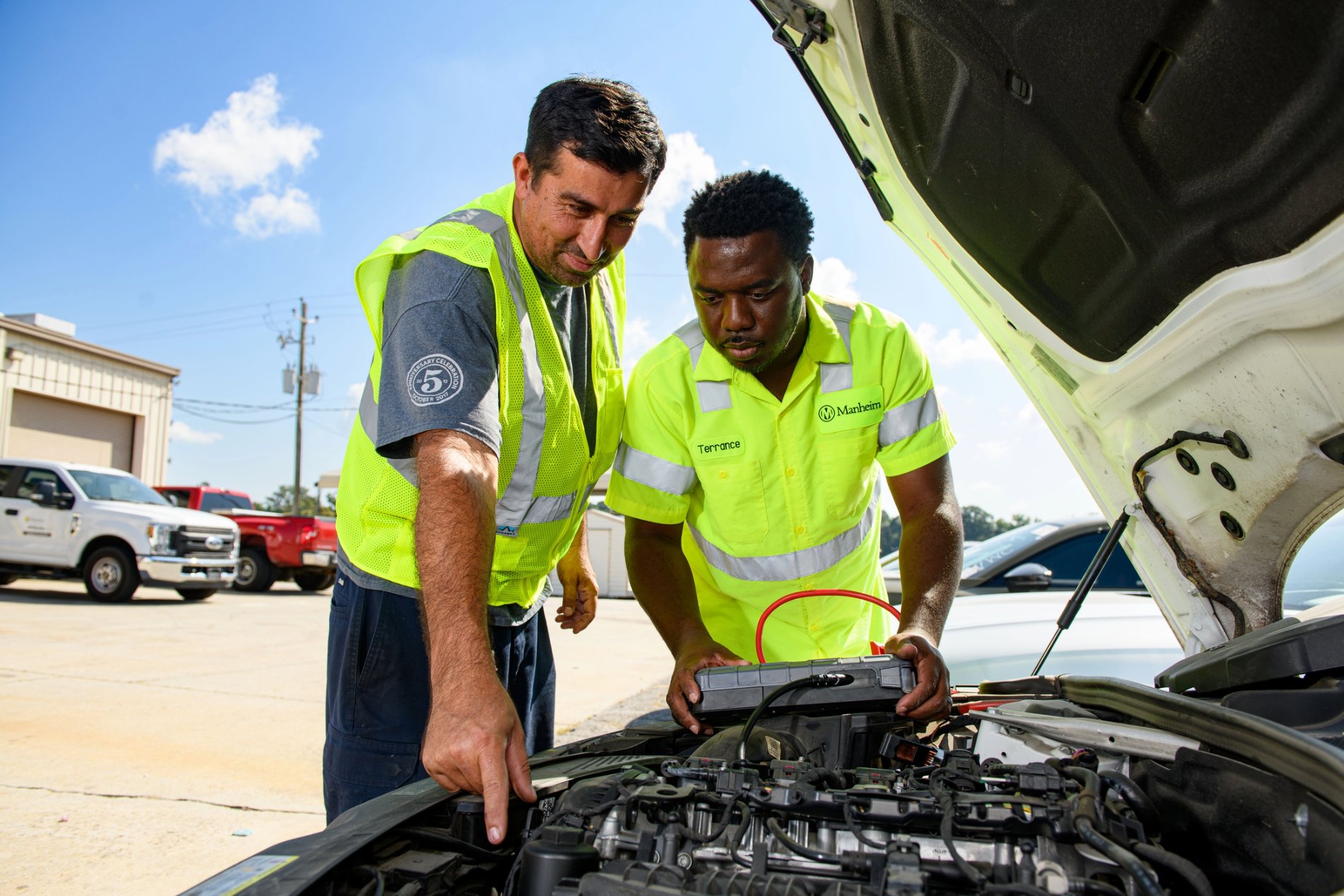 a group of cox automotive employees looking at an open hood of a car