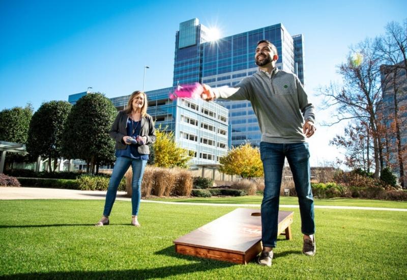 Cox employees Amit Vyas and Anne Gilk playing cornhole