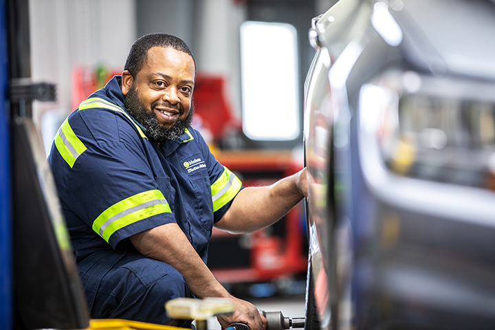 a Cox auto tech fixing vehicle