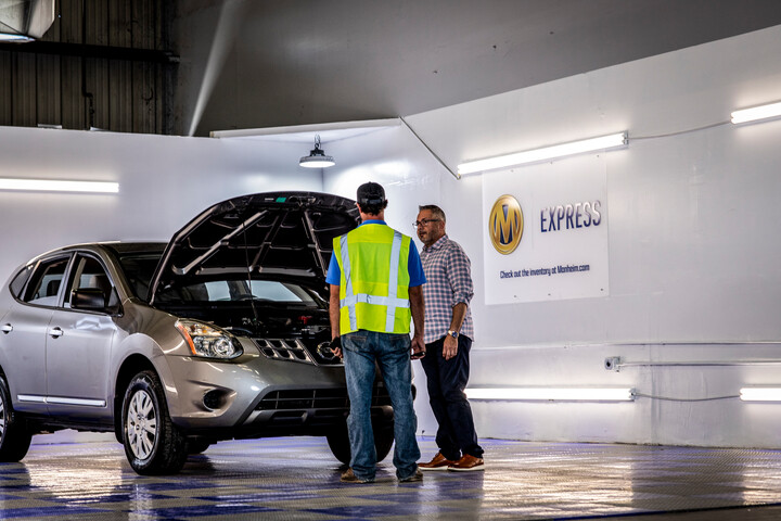 Cox Manheim employees working on car
