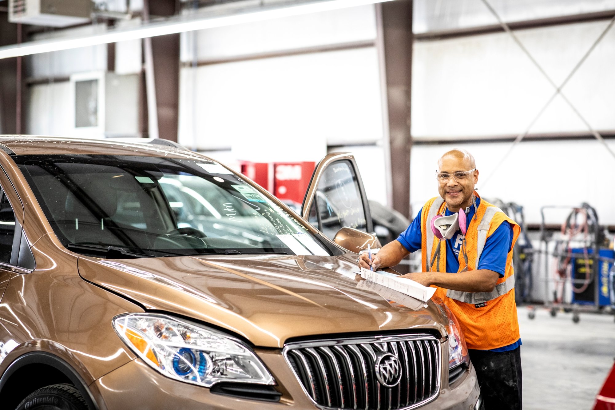 A Cox auto technician working on a car