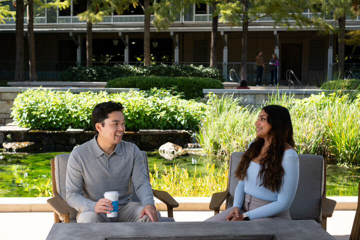 two Cox employees sitting at a table outside