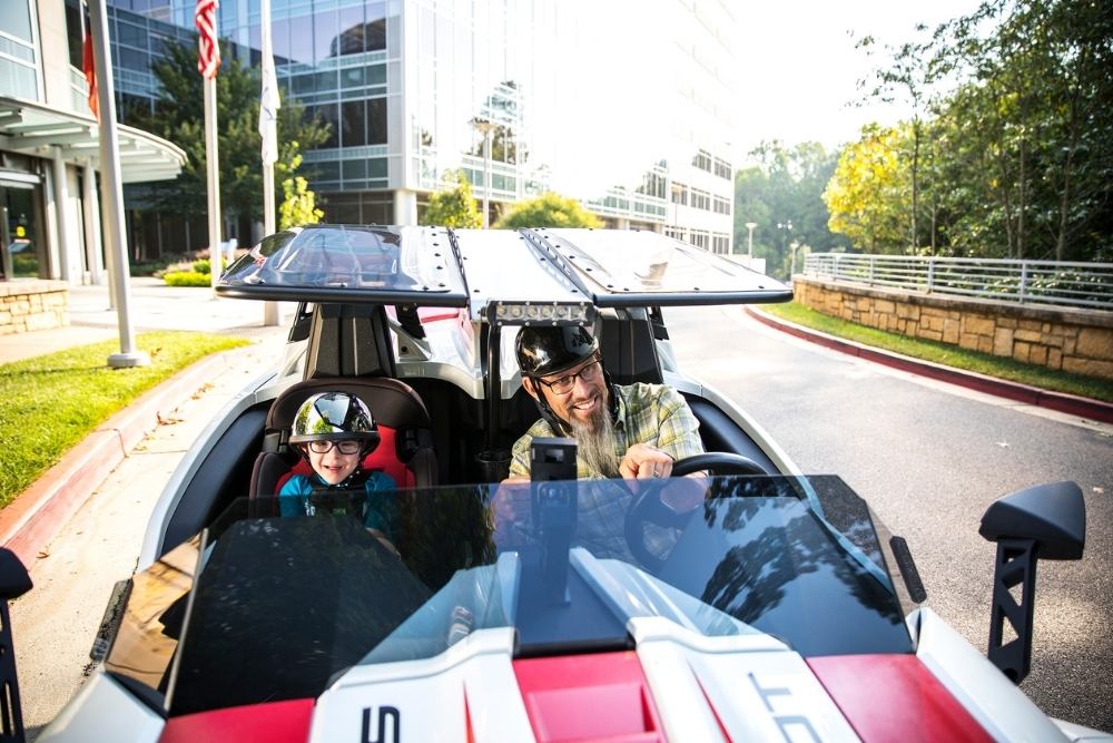 Cox employee racing a car with his son
