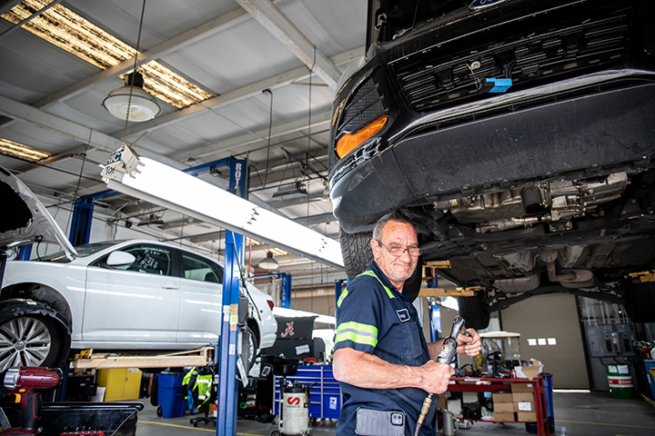 a Cox auto tech fixing vehicle