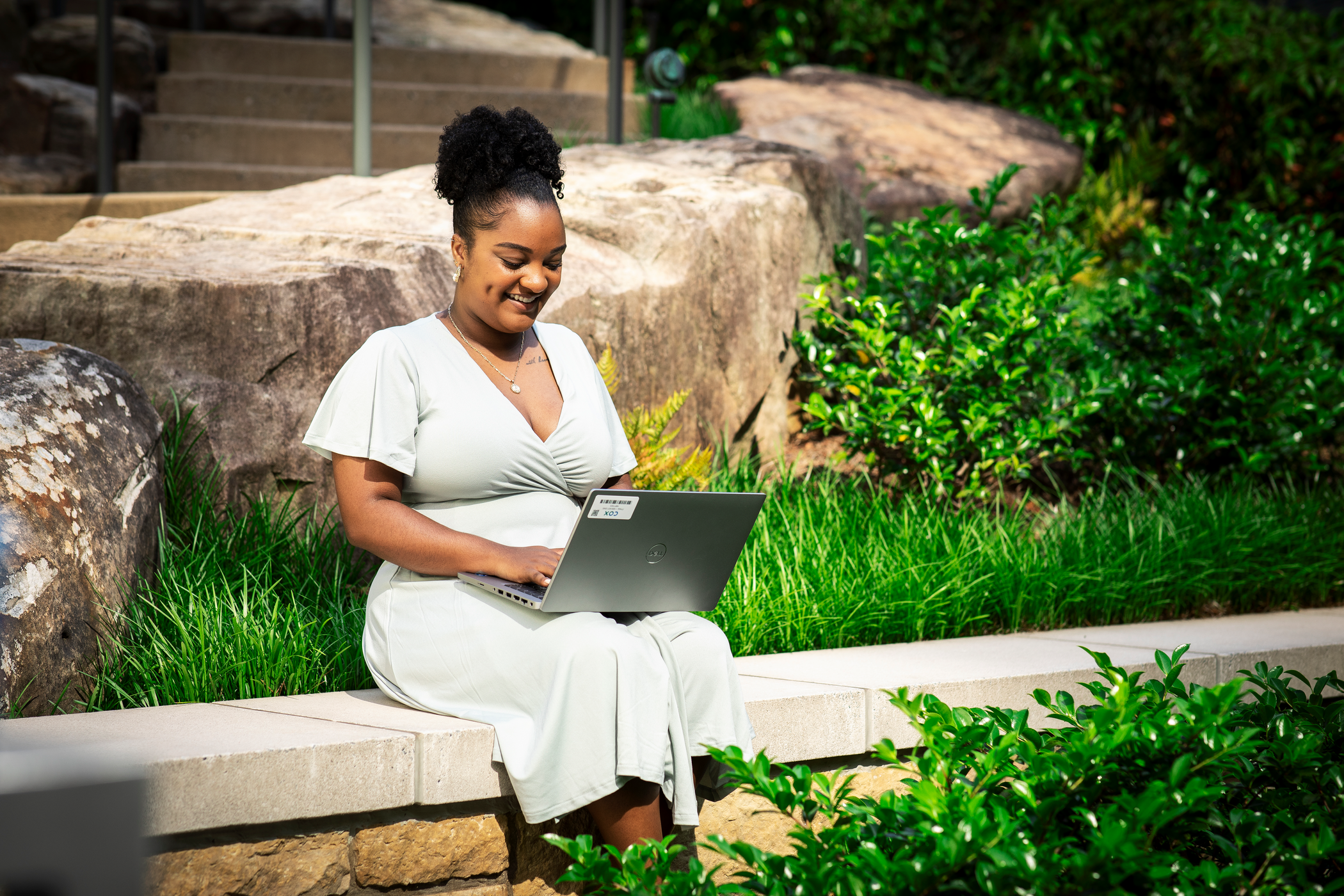 Cox employee working on laptop outdoors (1)