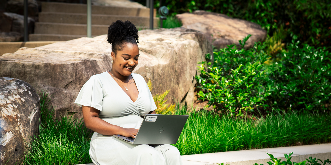 Cox employee working on laptop outdoors (1)