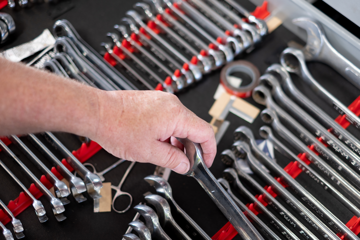 A hand picking up a wrench