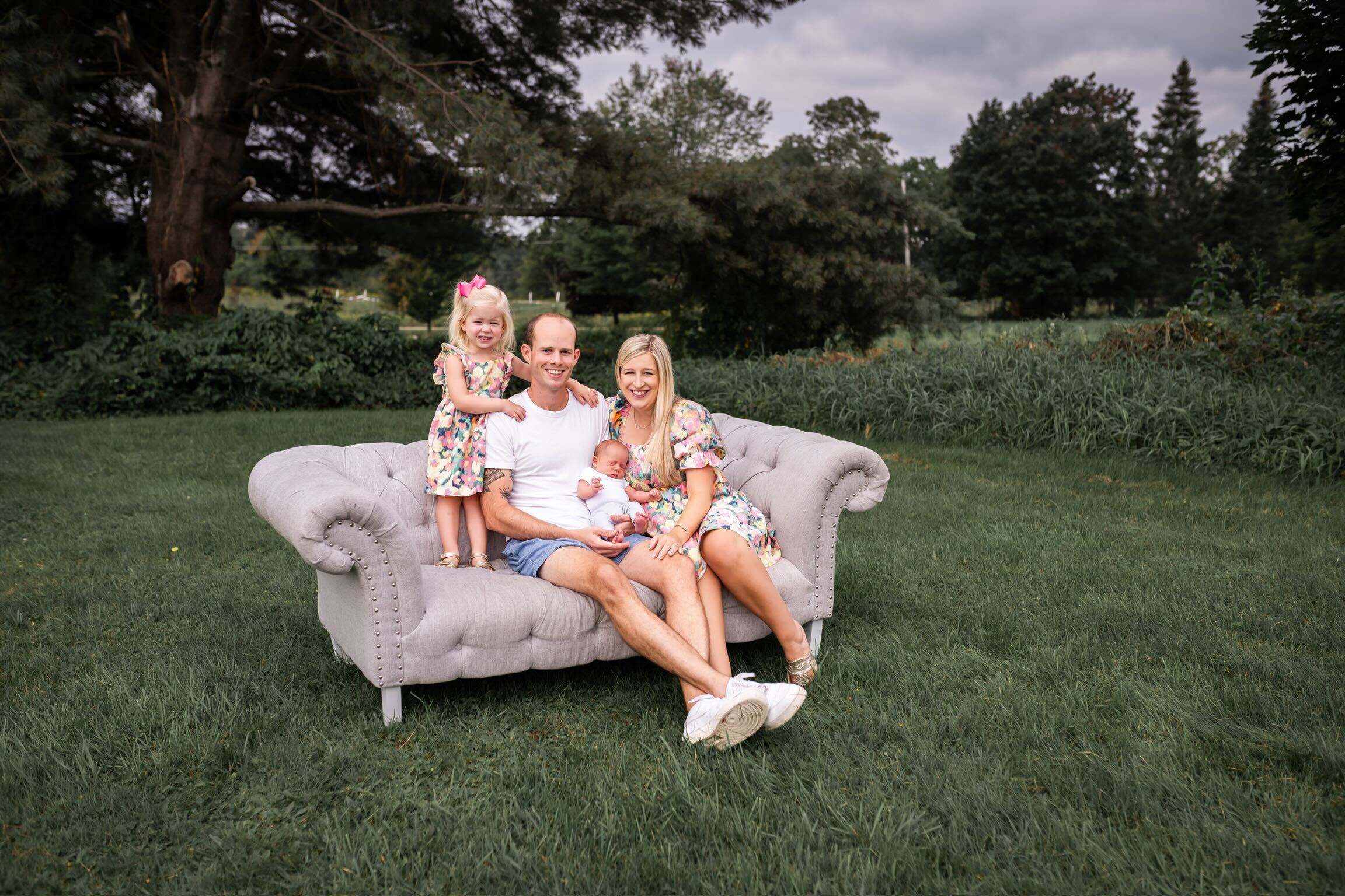 Anthony Jordick posing on his couch with his wife and two kids