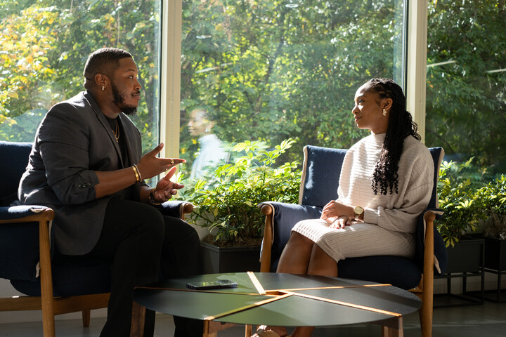 two Cox employees sitting in chairs talking