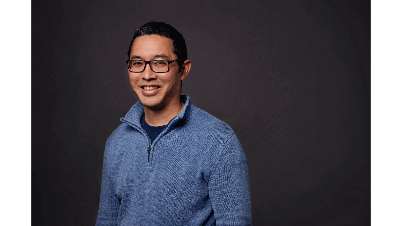 a person wearing glasses and a blue sweater