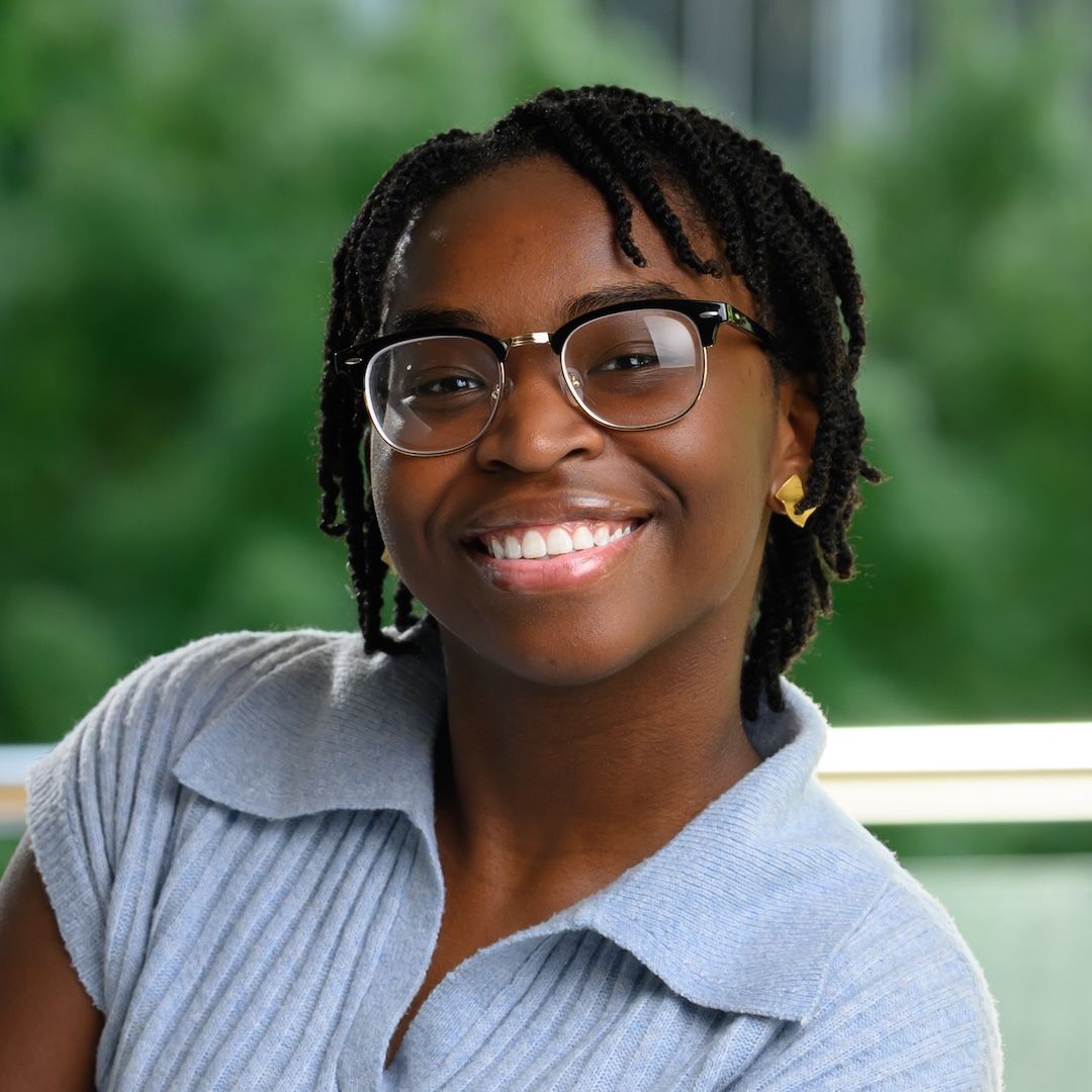 a person wearing glasses and smiling