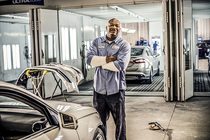 Cox auto tech crossing his arms and smiling