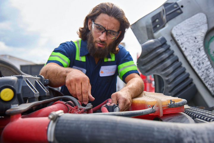 Cox Automotive mechanic working under hood of car