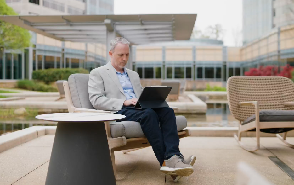 David Rice cox employee working on laptop by the ponds