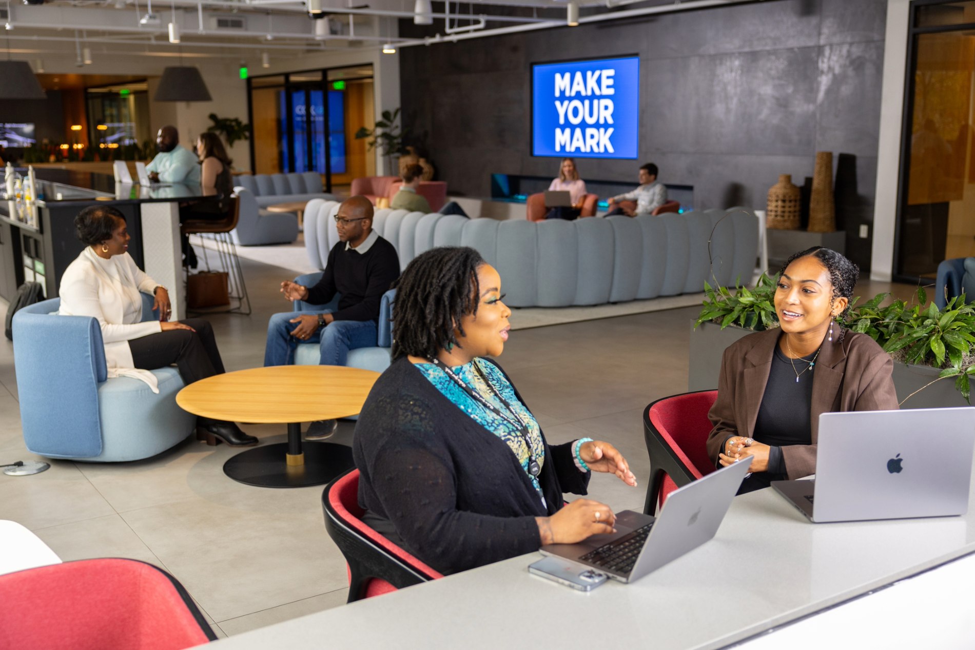 a group of Cox employees sitting in chairs and using laptops