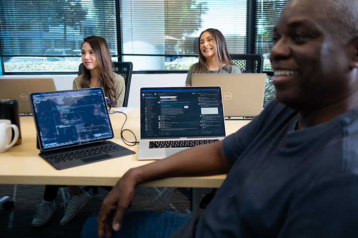 a group of Cox employees with their laptops in a meeting