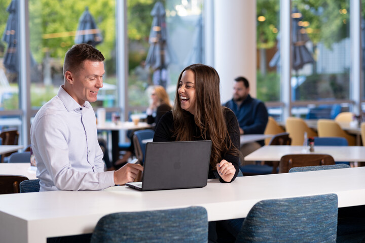 two Cox employees sitting at a table with a laptop